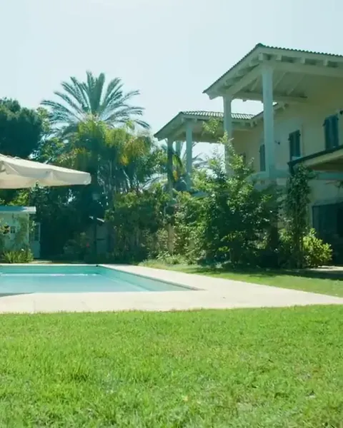 Villa bianca con piscina e un prato naturale rasato