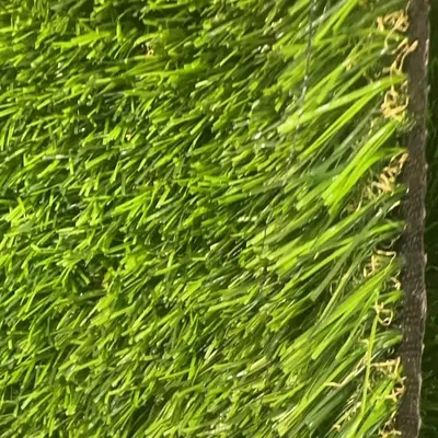 Fili di erba sintetica verde chiaro visti da vicino, accanto al bordo del supporto